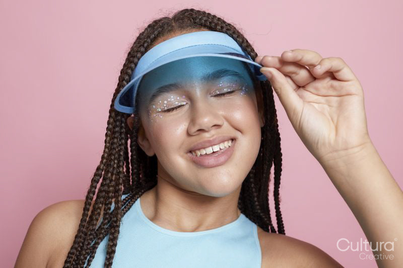 Studio portrait of smiling girl wearing sun visor