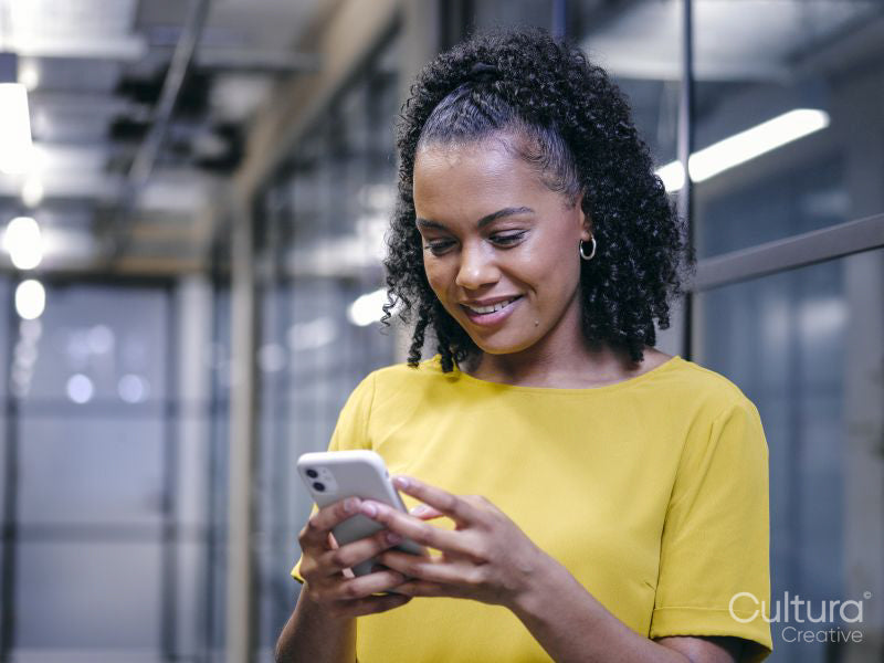 Woman using phone in office hallway