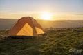 Tent in rural landscape at sunset