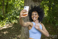 Young woman using smart phone to take selfie in forest