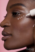 Young woman applying eye cream