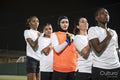 Team of female soccer players standing in row with hand on chest