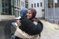 Two young women meeting in city
