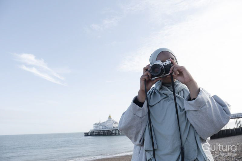 Portrait of Muslim woman photographing with analog camera