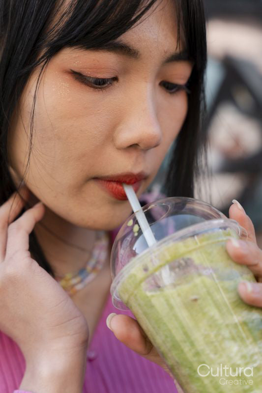 Close-up of young woman drinking sweet drink