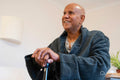 Senior man sitting on bed in room at nursing home
