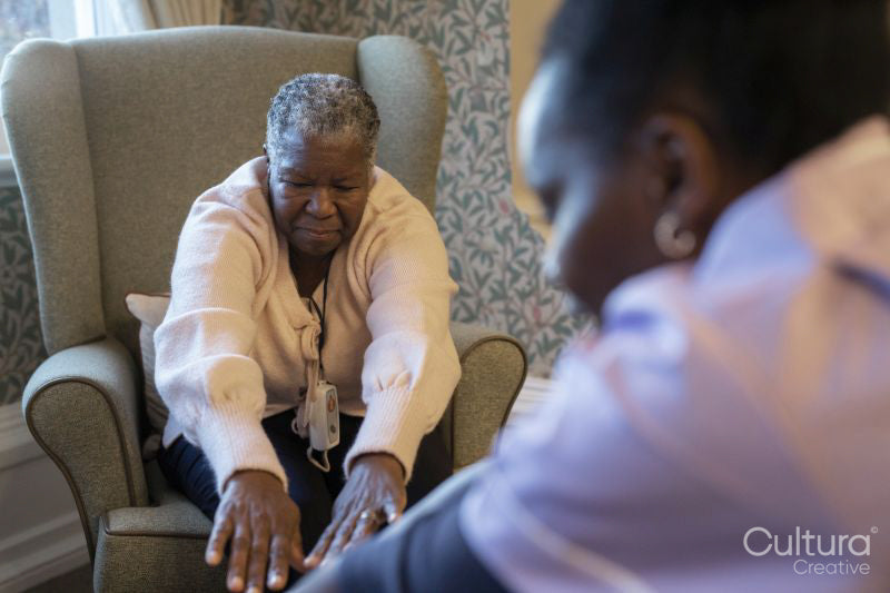 Senior woman exercising with nurse in nursing home