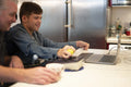 Disabled son using laptop with father
