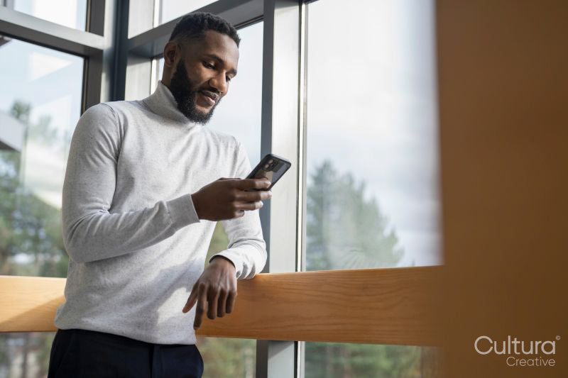 Young businessman using phone in office