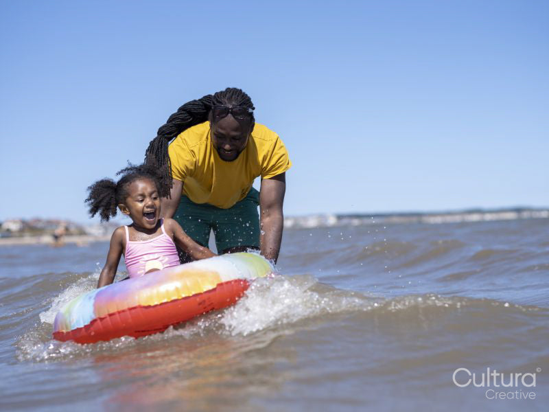 Father with daughter playing in sea