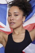 Studio portrait of smiling athletic woman holding British flag
