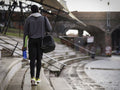 Rear view of athletic man with gym bag walking outdoors