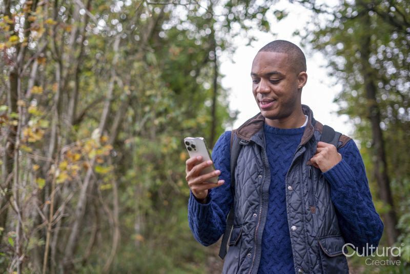 Man using smart phone during hike in autumn