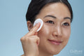Close-up of woman cleaning face with cotton pad