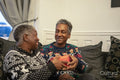 Senior couple sitting on sofa holding Christmas gifts