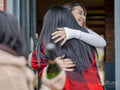 Women greeting at door while visiting friend in house