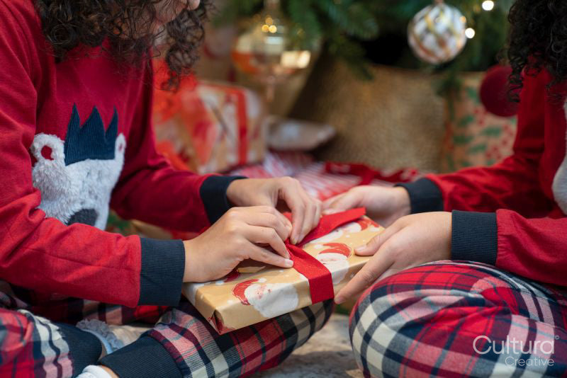 Close-up of sisters unpacking Christmas gift