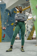 Portrait of smiling athletic woman at climbing wall at gym