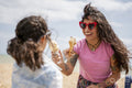 Mother and daughter eating ice cream on beach