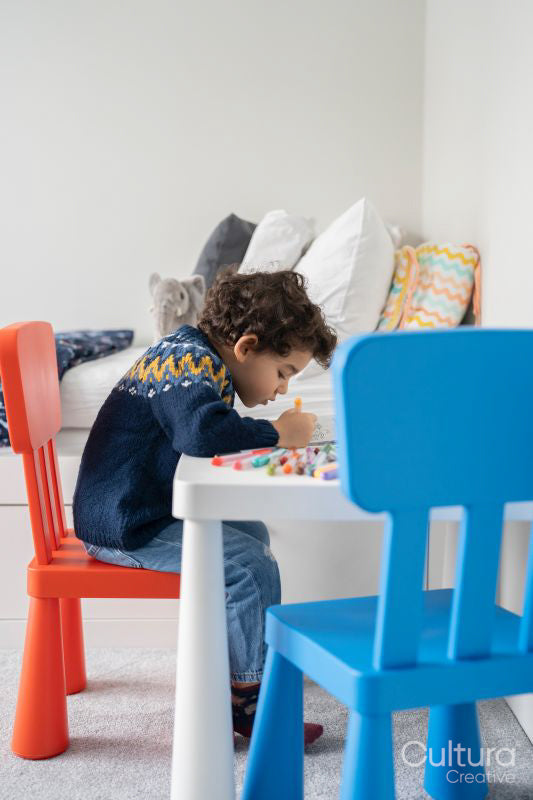 Boy coloring in coloring book at home