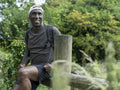 Smiling mature man sitting on fence on hike