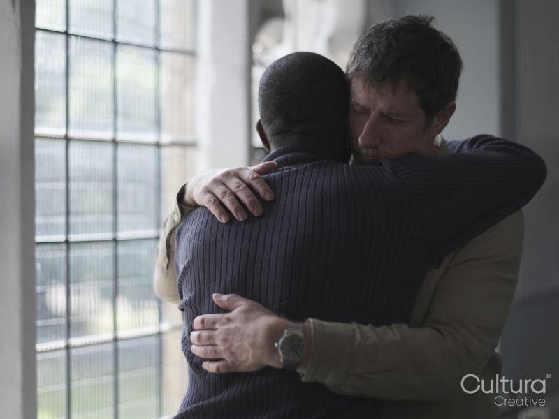 Men hugging in therapy session