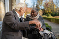 Smiling senior people relaxing on bench in park