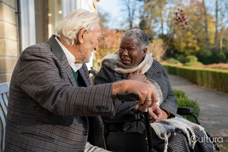 Smiling senior people relaxing on bench in park
