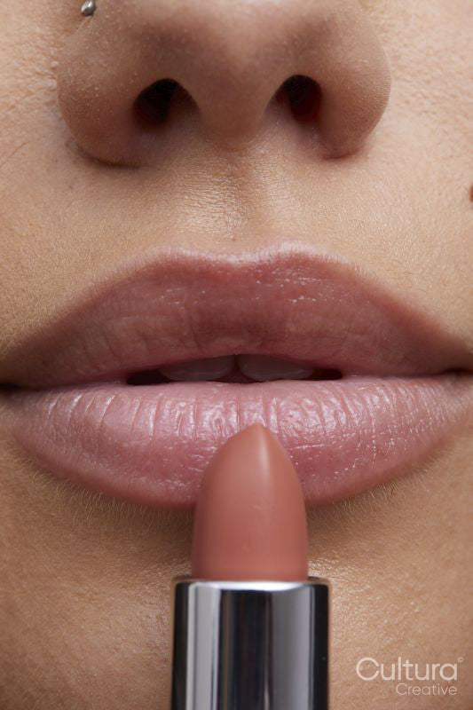 Close-up of young woman applying lipstick