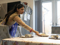 Young woman in traditional clothing setting table