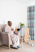 Smiling senior woman sitting in armchair, holding mug