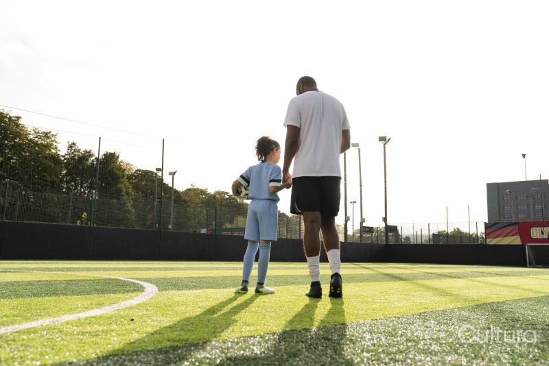 Rear view of coach and girl on soccer field