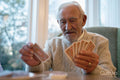 Senior man playing cards at table