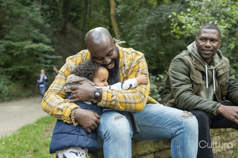 Smiling father hugging daughter in park