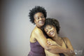 Studio shot of smiling mother and daughter wearing lingerie