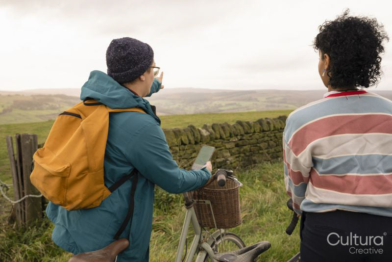 Female friends cycling on rural road