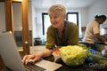 Smiling senior woman looking at laptop in kitchen