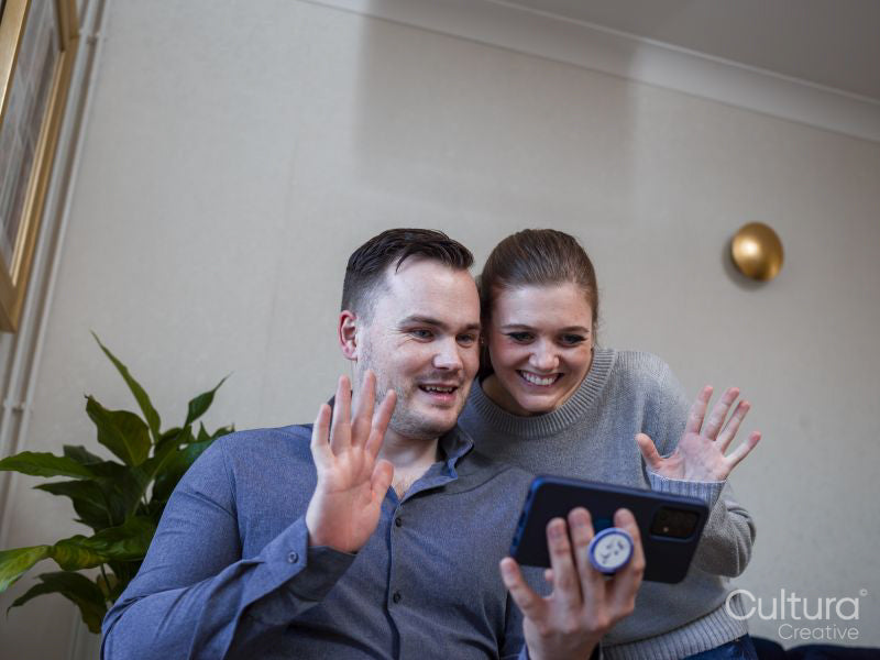 Smiling couple having video call via smart phone at home
