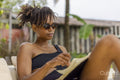 Woman in swimsuit reading on terrace