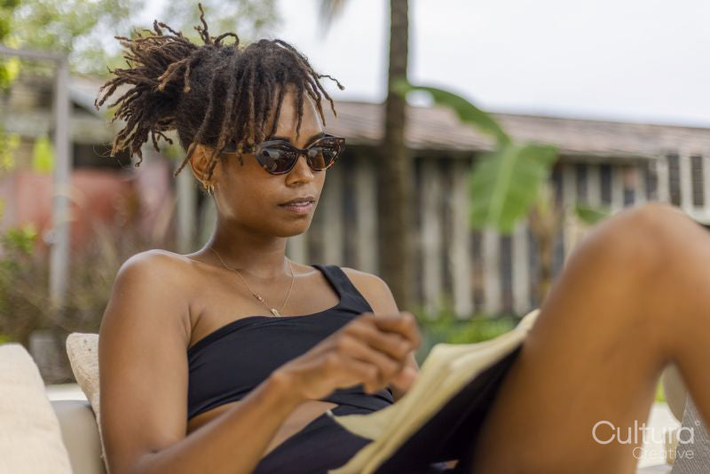 Woman in swimsuit reading on terrace