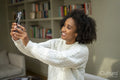 Smiling woman taking selfie at home
