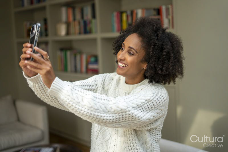 Smiling woman taking selfie at home