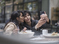 Female couple taking selfie in restaurant