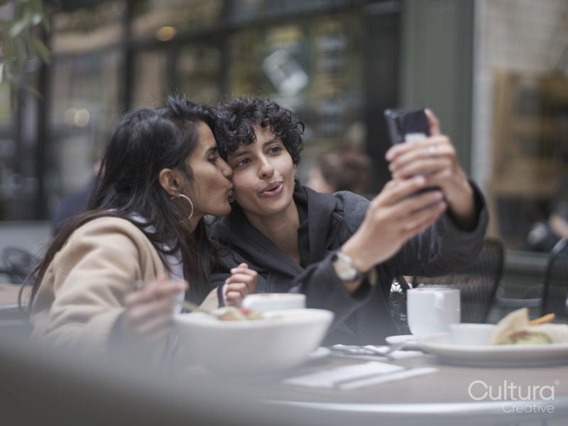 Female couple taking selfie in restaurant