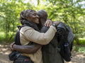 Smiling hiking couple hugging in forest