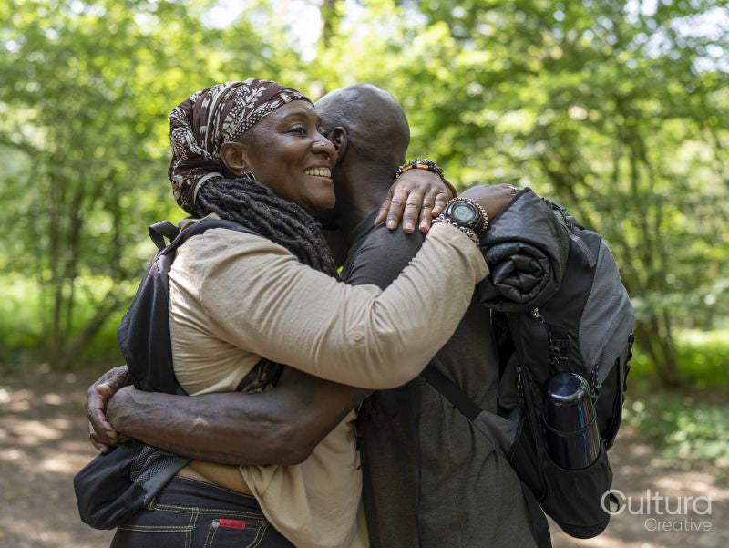 Smiling hiking couple hugging in forest
