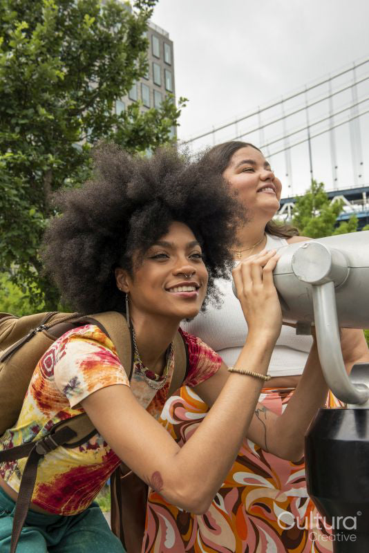 Two women using telescope for sightseeing