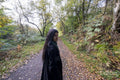 Portrait of woman standing on footpath in forest