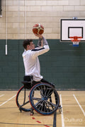 Male basketball player in wheelchair shooting ball