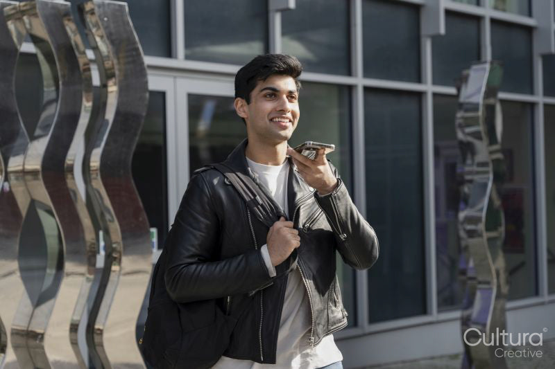 Smiling male student using phone